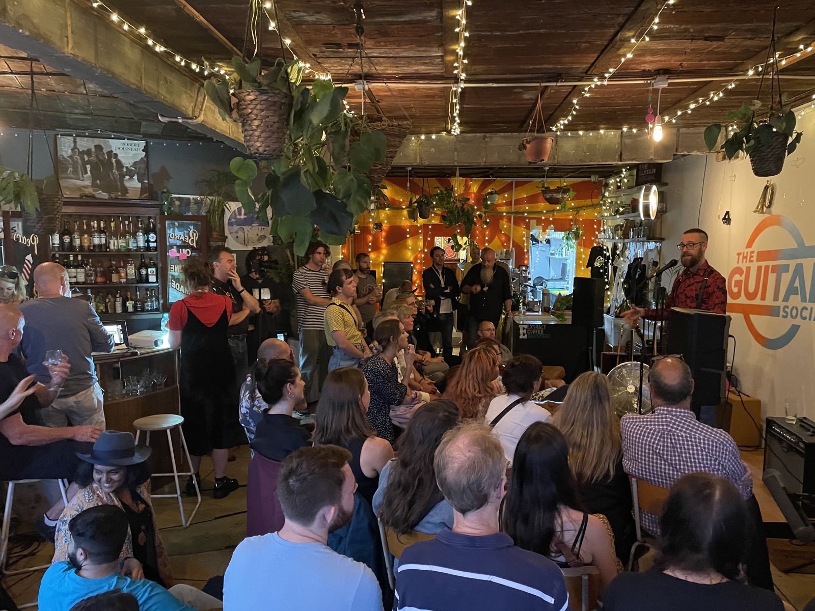 Dan hosting a packed, fairy-lit room of people at the On the Cotton showcase