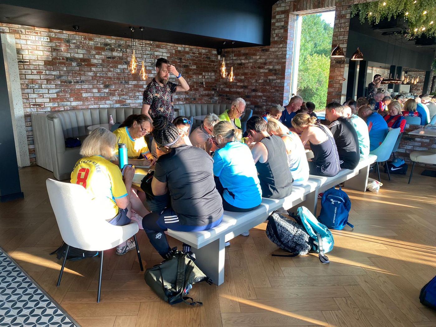 Dan leading a writing workshop with Crystal Palace supporters around a long table