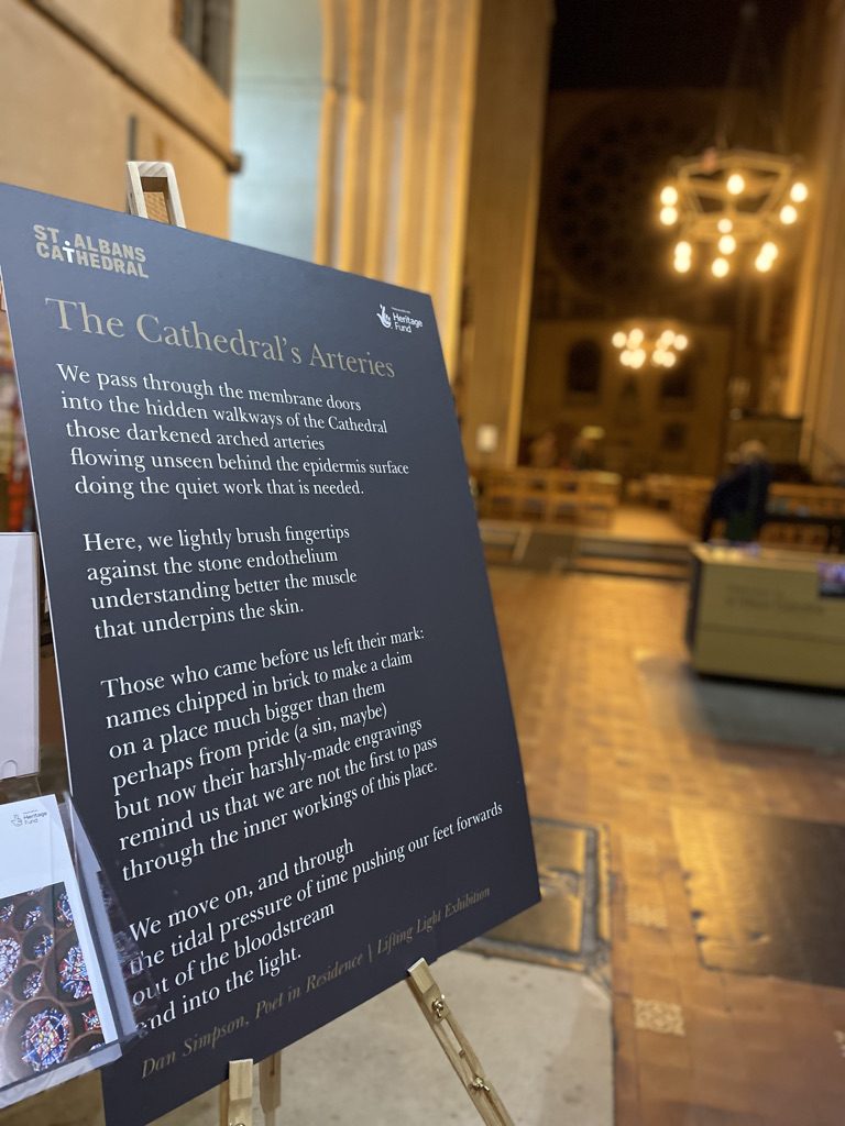 A display board in St Albans Cathedral showing Dan's poem The Cathedral's Arteries